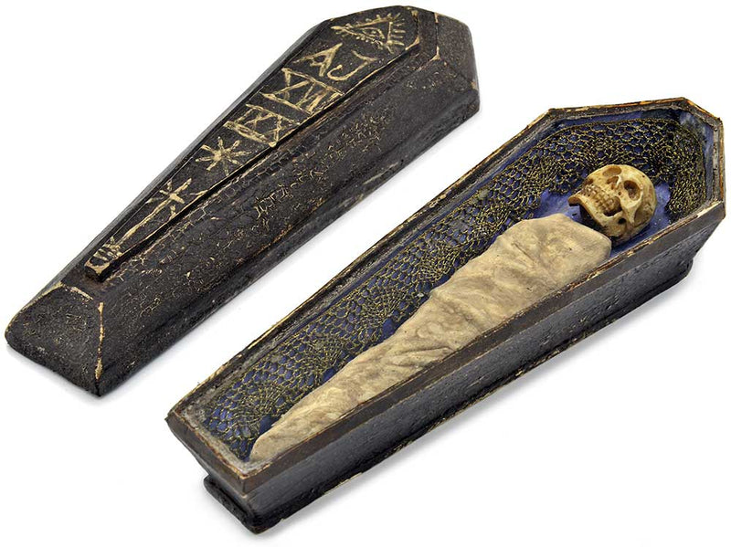 Closed antique coffin with hand carved skeleton and coffin lid with symbols